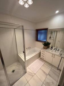 奥尔伯里Grand retreat in town的带淋浴、浴缸和盥洗盆的浴室