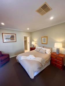 奥尔伯里Grand retreat in town的一间卧室配有一张大床和一把椅子
