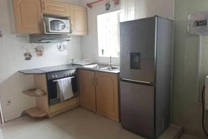 布兰太尔Nichi's Guesthouse - Cosy 3 bedroom with breakfast的厨房配有不锈钢冰箱和水槽