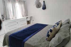 布兰太尔Nichi's Guesthouse - Cosy 3 bedroom with breakfast的一间卧室配有一张带蓝色床单的床和一扇窗户。