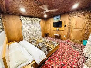 斯利那加The Hayat Group Of Houseboats的一间卧室配有床、电视和地毯。