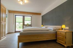 奥夫塞斯Ferienwohnung Kobelsberg的一间卧室设有一张大床和一个窗户。