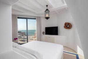 Al RahbaAnantara Santorini Abu Dhabi Retreat-Adults Only的白色的客房配有床和电视