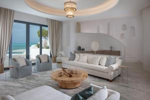 Al RahbaAnantara Santorini Abu Dhabi Retreat-Adults Only的客厅配有沙发、椅子和桌子