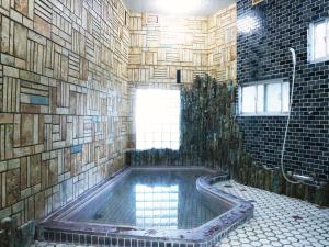 生驹Kanko Ryokan Yamato的一间带浴缸的浴室和瓷砖墙