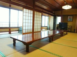 生驹Kanko Ryokan Yamato的窗户客房内的木桌
