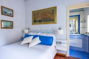 那不勒斯La Casa Di Bruno Napoli的卧室配有白色的蓝色调床。
