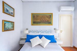 那不勒斯La Casa Di Bruno Napoli的一间卧室配有一张带蓝色和白色枕头的床