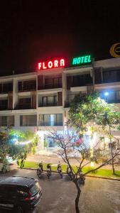 富国FLORA Hotel Phu Quoc的夜间停泊在停车场的摩托车酒店