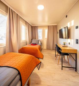 上维耶斯卡Hotelli Visiitti的客房设有两张床、一张桌子和一张桌子。