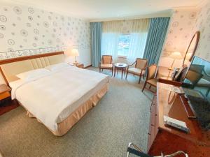 基隆长荣桂冠酒店 - 基隆的酒店客房设有一张大床和一张书桌。