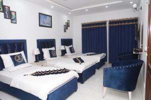 拉合尔Hotel Royal Comfort的蓝色和白色的客房内的三张床