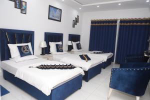 拉合尔Hotel Royal Comfort的蓝色和白色的客房内的两张床