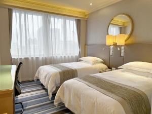 广州广州远洋宾馆（广交会期间提供免费接驳巴士）的酒店客房,设有两张床和镜子