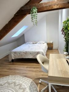 奥尔良Maison de charme - accès autonome的阁楼卧室配有两张床和一张桌子
