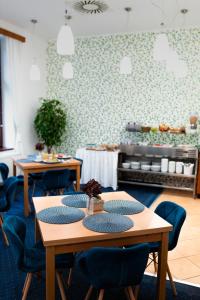 利托梅日采Hotel Apollon的一间配备有桌子和蓝色椅子的用餐室