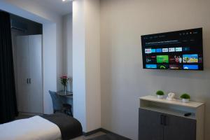 阿克套Tengri Hotel的卧室配有一张床,墙上配有电视。