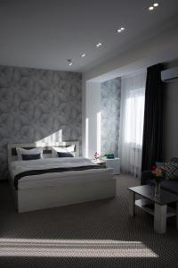 阿克套Tengri Hotel的卧室配有一张白色的大床和一张桌子