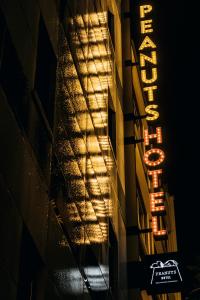 神户ピーナッツホテル/PEANUTS HOTEL的夜间建筑物一侧的标志