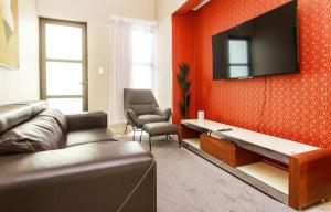 OngwedivaMorningSide Fortyfive的客厅配有沙发和墙上的电视