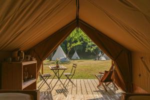 米瑞德Ca Stella Camping del Monte San Giorgio的帐篷配有桌椅和帐篷