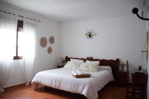 阿尔科斯-德拉弗龙特拉Hostal Rural La Plata Parking Incluido的一间卧室配有一张带白色床单的床和一扇窗户。