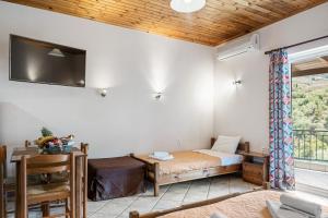阿约斯尼奇塔斯Rania Apartments的卧室配有一张床,墙上配有电视。