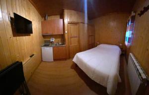里贝拉德卡多斯Camping Bungalows La Borda del Pubill的一间带床的小卧室和一间厨房