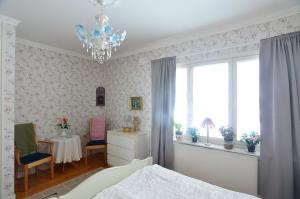 ÖverkalixVilla Sisu的一间卧室配有一张床、一张桌子和一个吊灯。