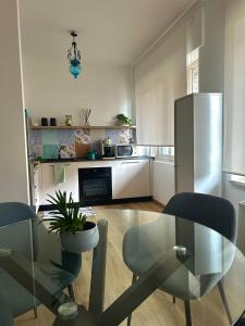 陶尔米纳Taormina Casa Sarina的厨房配有玻璃桌和冰箱