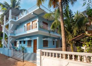 西奥利姆Whiteboard Homes Siolim的一座棕榈树的蓝色房子