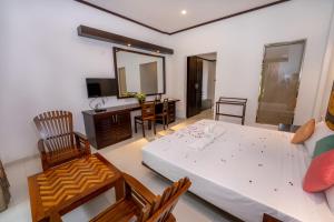 瓦都瓦Nirmala Hotel的一间卧室配有一张床、一张桌子和一面镜子
