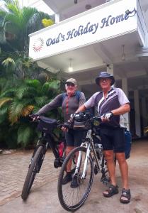 马特莱Dad's Holiday Home的两个人站在一座建筑物前面,骑着自行车