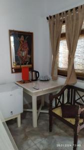 乌纳瓦图纳Full Moon Resort的一张带椅子的白色书桌和墙上的照片