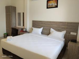 钦奈RedFox Hotel-T.Nagar的卧室配有一张带白色床单和枕头的大床。