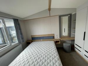 斯凯格内斯Royal Oak Caravan Park的一间小卧室,配有一张床和镜子