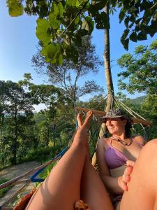康提Little wood villa Doluwa的两名妇女躺在丛林中的吊床上