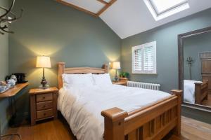 切尔滕纳姆Stable Lodge - Boutique Bed & Breakfast的一间卧室设有一张大床和一个窗户。