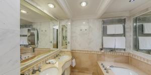 沃尔特湖畔韦尔登韦尔登富肯斯坦纳城堡酒店-世界顶级酒店集团的浴室配有2个盥洗盆、浴缸和镜子