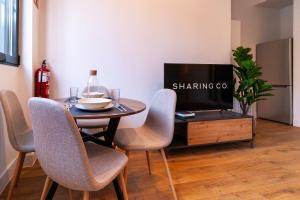 马德里Simancas by SharingCo的一间带桌椅和电视的用餐室