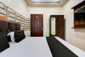 坎普尔OYO Flagship Hotel M. R Galaxy的一间卧室配有一张床和一扇木门