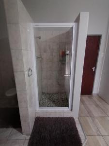 奥茨胡恩Oppi Draai Guesthouse的浴室里设有玻璃门淋浴