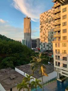 八打灵再也Cozy duplex facing misty hill的享有棕榈树和建筑的城市美景