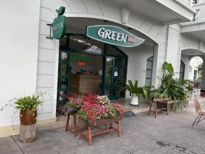 富国Green Inn Phu Quoc Hotel的前面有鲜花的绿色旅馆商店