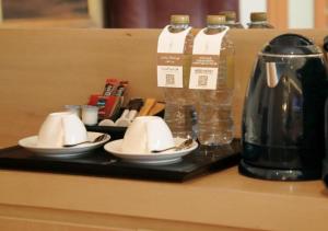 迪拜迪拜H酒店的盘子上装有杯子和瓶装水