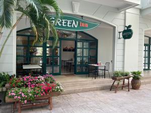 富国Green Inn Phu Quoc Hotel的前面有鲜花的绿色旅馆餐厅