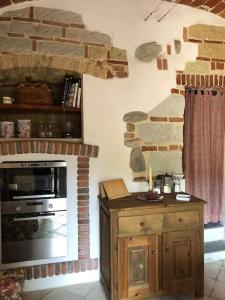Serralunga di CreaCa' Cuore in Monferrato的厨房设有石制壁炉和炉灶。