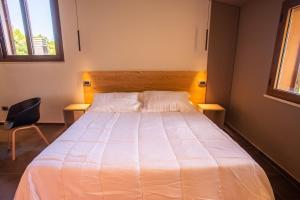 阿斯普罗蒙特的冈比亚Park Hotel Bellavista的卧室配有一张白色大床和椅子