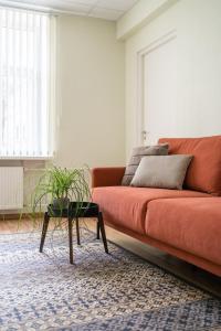科赫特拉-耶尔韦Virumaa Hostel的客厅配有橙色沙发和桌子