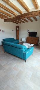 洛什La Belle de la Gaieté的客厅配有蓝色的沙发和桌子